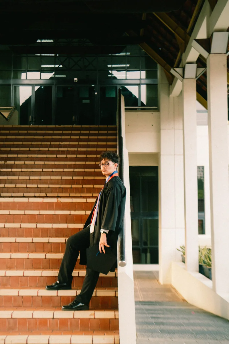 Wahyu sitting on a staircase at night